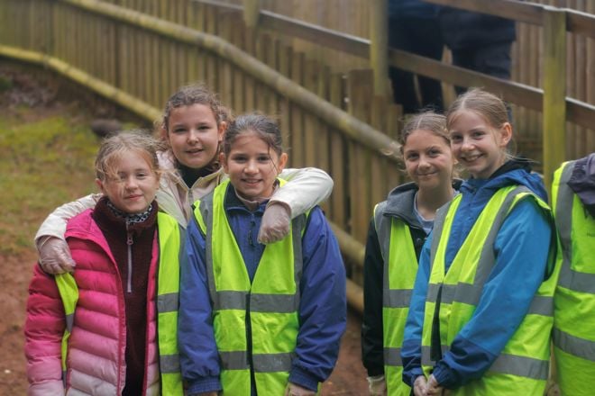 5 workshop children in high vis jackets smile for the camera next to enclosures at woburn safari park 