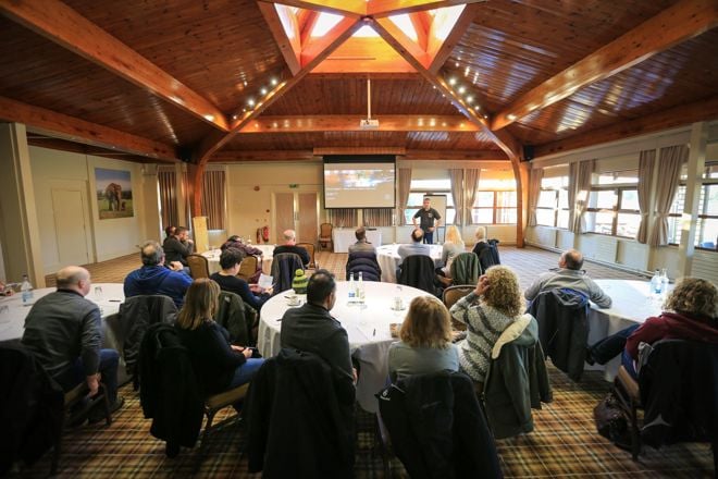 Corporate group listening to presentation in Safari Lodge set up with tables 